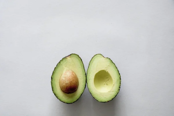 Высокий угол съемки свежего вкусного авокадо на белой поверхности — стоковое фото