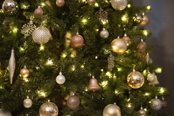 Kerstboom versierd met verlichting en speelgoed tegen een wazige achtergrond — Stockfoto