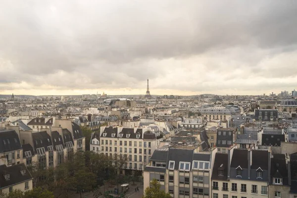Hochwinkelblick auf Gebäude in Paris mit dem Eiffelturm unter einem bewölkten Himmel im Hintergrund — Stockfoto