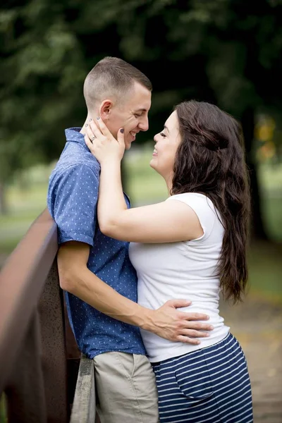Vertical shot of a couple holding each other near the beautiful trees — Stock Photo, Image