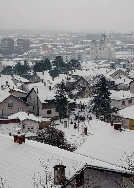Vista de alto ângulo de uma cidade com edifícios e árvores cobertas de neve e nevoeiro — Fotografia de Stock