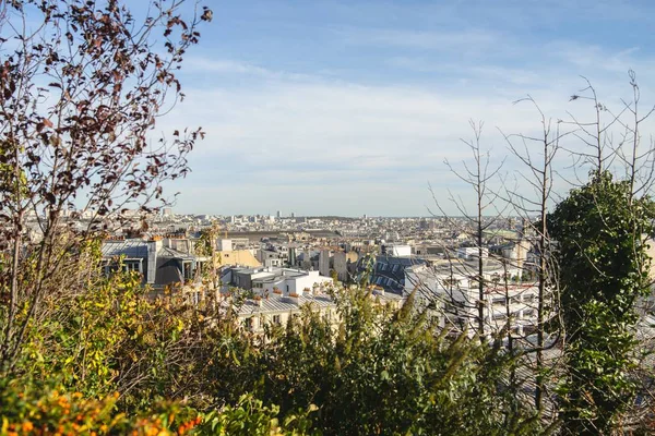 Paysage d'une ville entourée de verdure sous le soleil et un ciel nuageux — Photo