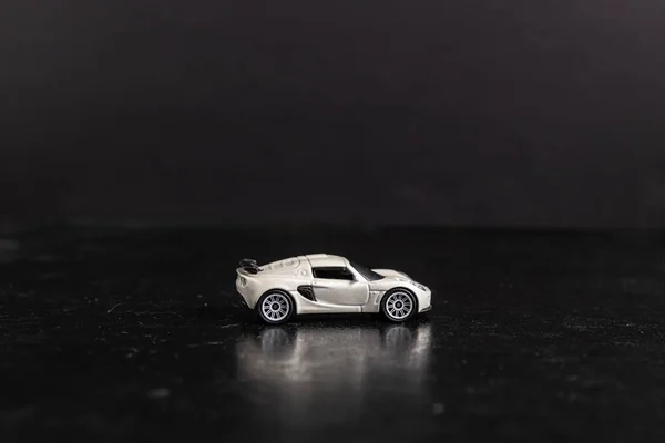 Selektiv fokus skott av en vit leksak sportbil på en svart yta — Stockfoto