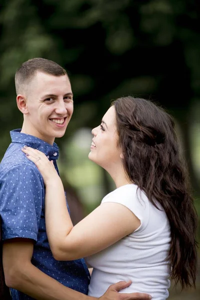 Vertical shot of a happy white couple enjoying each other's company in the middle of a park — ストック写真