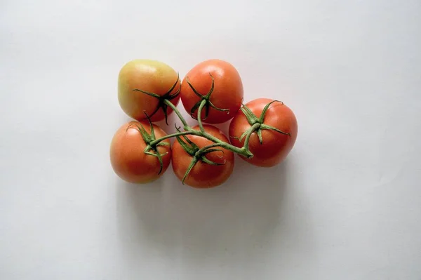 Duże ujęcie kąta niektórych pomidorów na białej powierzchni — Zdjęcie stockowe