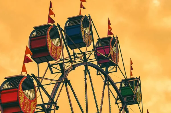 Χαμηλή γωνία άποψη των πολύχρωμων Ferris Wheel καμπίνες σε ένα πάρκο διασκέδασης κατά τη διάρκεια της βραδιάς — Φωτογραφία Αρχείου