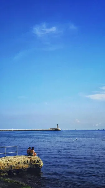 Вертикальний знімок маяка на березі океану під чистим небом — стокове фото