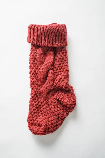 Alte angolazioni verticali di una calza a maglia su una superficie bianca — Foto Stock