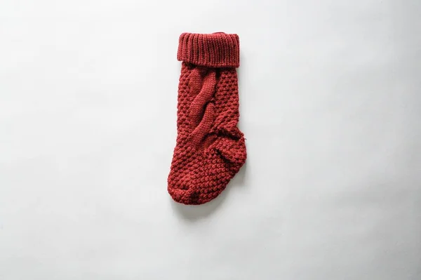 Colpo di primo piano di angolo alto di un calzino festivo rosso su una superficie bianca — Foto Stock