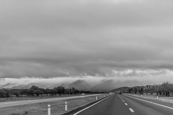 Сірий Знімок Дороги Горами Відстані Під Хмарним Небом — стокове фото