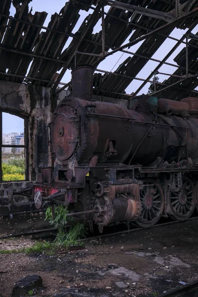 Vertikale Aufnahme einer alten Lokomotive in einem alten Bahnhofsgebäude im Libanon — Stockfoto