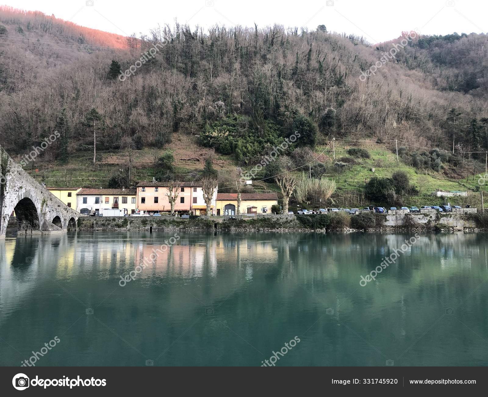 Devil bridge surrounded by hills covered in forests and houses