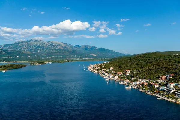 Magas szög lövés épületek közelében a tó és a hegyek a távolban Kotor, Montenegró — Stock Fotó