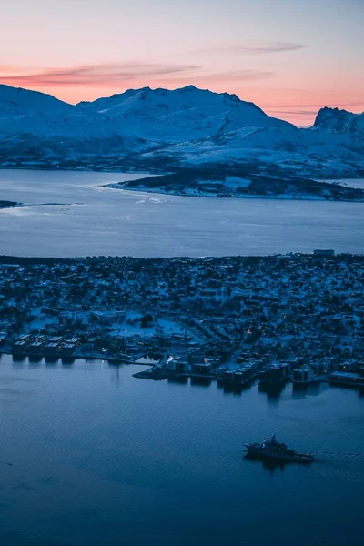 在挪威特罗姆瑟拍摄的建筑物和覆盖着高山的积雪的空中照片 — 图库照片