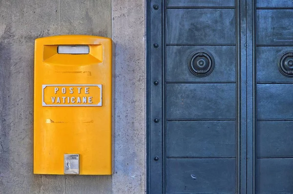 Duvarda mavi metal bir kapının yanında sarı posta kutusu var. — Stok fotoğraf