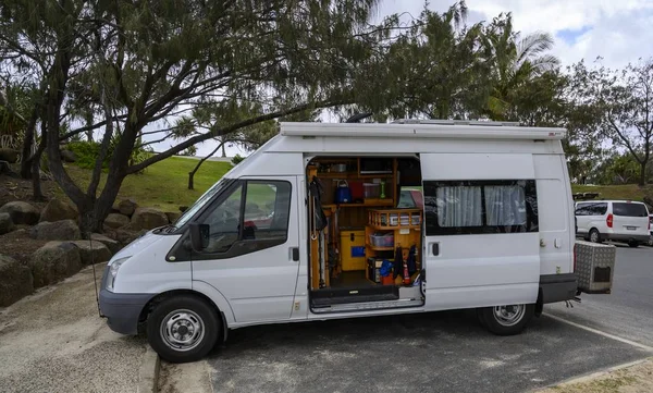 Van compacta branca com bens domésticos nele em um parque cercado por vegetação — Fotografia de Stock