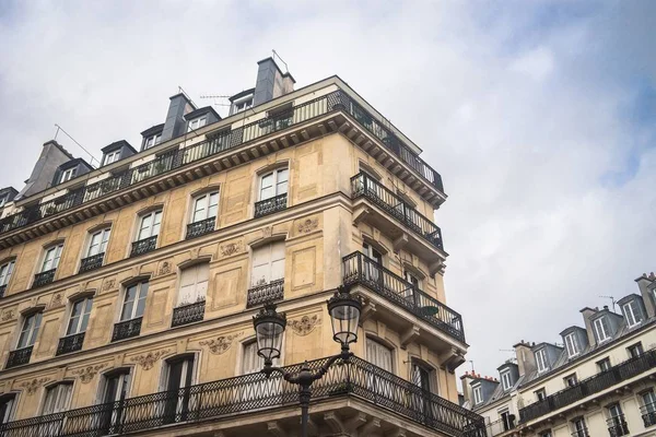 Vista de baixo ângulo de edifícios com varandas sob um céu nublado em Paris, na França — Fotografia de Stock