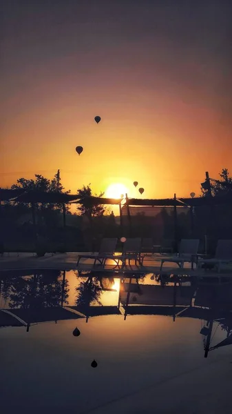 Pionowe ujęcie spadochronów lecących podczas zapierającego dech w piersiach zachodu słońca — Zdjęcie stockowe