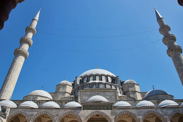 Baixo ângulo tiro de uma mesquita com escrita turca sobre ele e um céu azul claro no fundo — Fotografia de Stock