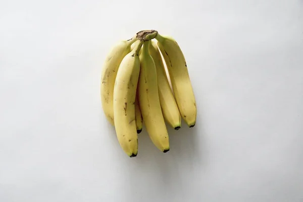 High angle shot of fresh delicious yellow bananas on a white surface — ストック写真