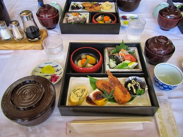 Nagy látószögű kilátás élelmiszer egy fekete edény az asztalon egy fehér abroszt — Stock Fotó