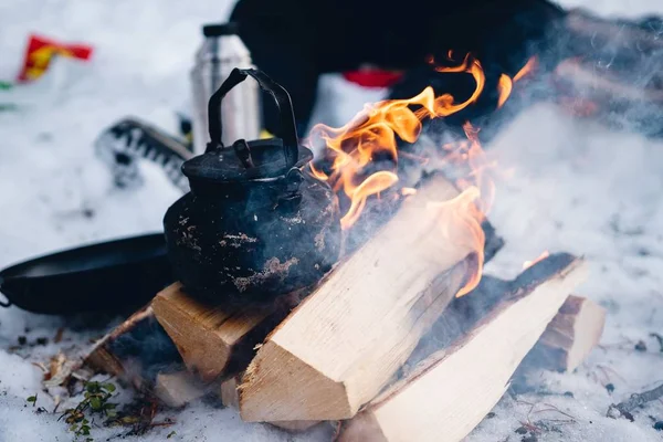 Primer plano de una tetera de metal sobre madera en llamas en el invierno en el norte de Suecia — Foto de Stock