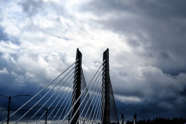 Vue en angle bas d'un pont entouré d'un paysage vert touchant le ciel nuageux — Photo