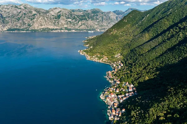 Alto ángulo de tiro de edificios cerca de las montañas boscosas y el lago en Kotor, Montenegro — Foto de Stock