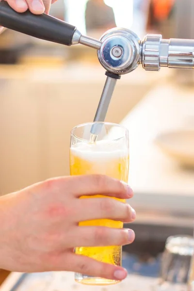 Vertical shot of a person pouring beer in the glass — Stock Photo, Image