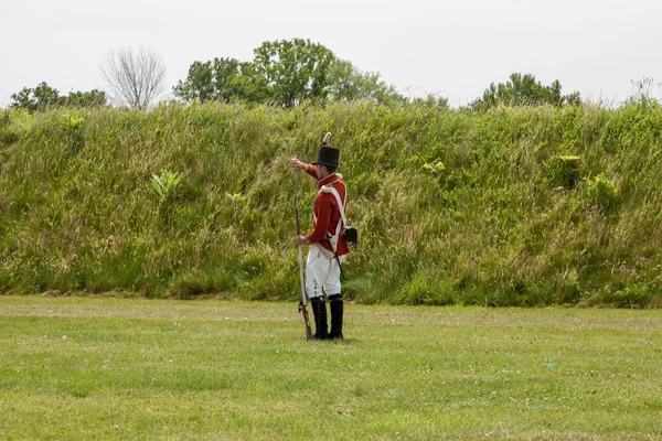 Soldado del siglo XVIII se prepara para disparar un mosquete — Foto de Stock