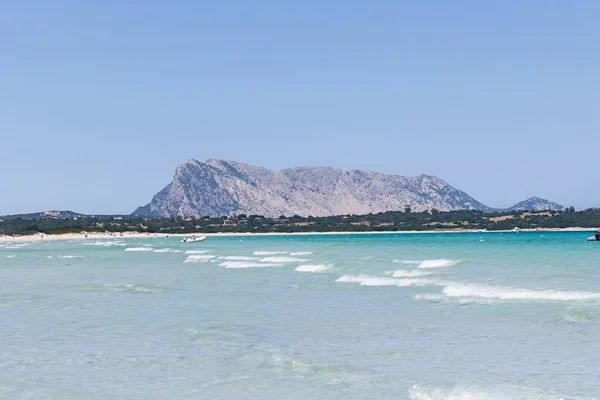 撒丁岛San Teodoro海滩上清澈的地中海水带着山丘背景 — 图库照片