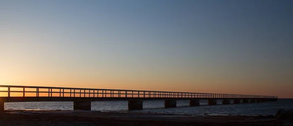Amplio plano de un puente sobre el mar con un hermoso cielo en el fondo —  Fotos de Stock