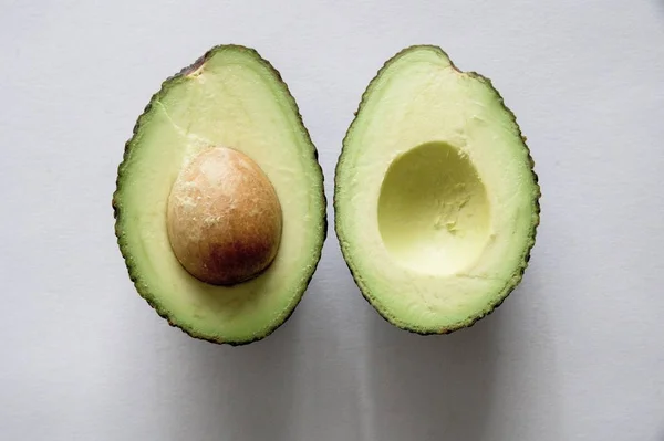 Hochwinkelaufnahme von frischer köstlicher Avocado auf weißer Oberfläche — Stockfoto