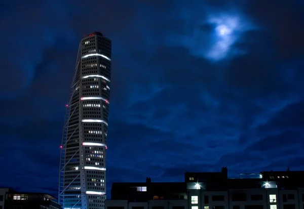 Vacker bild av en skyskrapa med tända ljus och en mörkblå himmel i bakgrunden på natten — Stockfoto