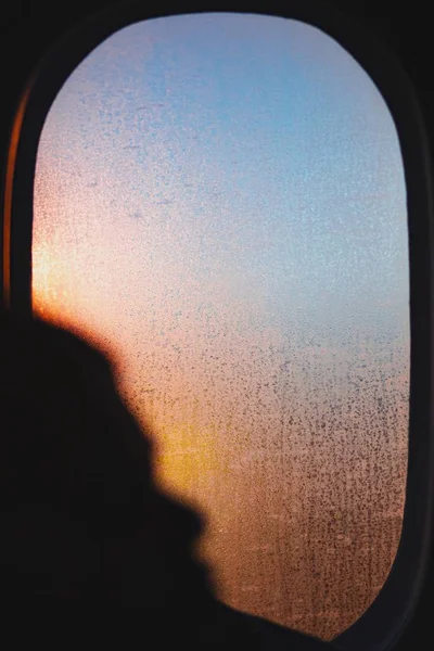 Gőz borítja a repülő ablakát egy gyönyörű napfelkelte alatt. — Stock Fotó