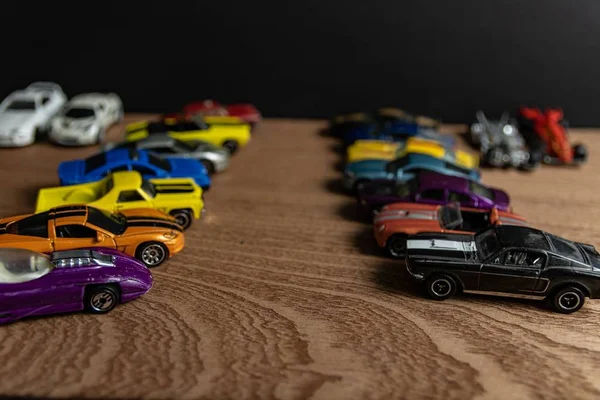 Selective focus shot of toy sports cars in a line on a wooden surface — Stock Photo, Image