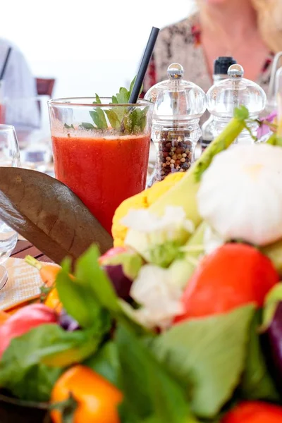 Messa a fuoco verticale selettiva di una bevanda rossa con una foglia vegetale — Foto Stock