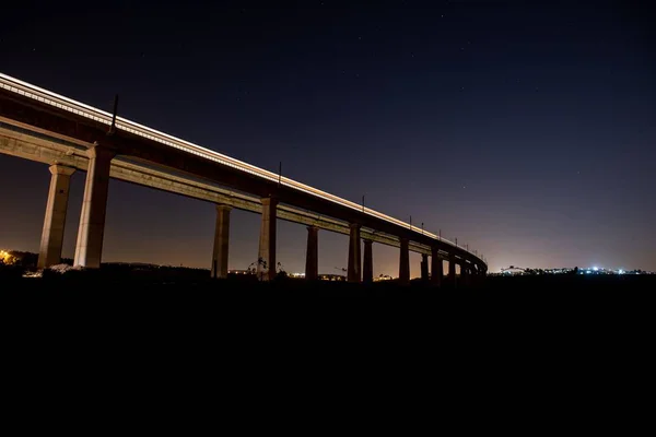 Дровяной мост с эффектом движения в окружении света и зелени в ночное время — стоковое фото