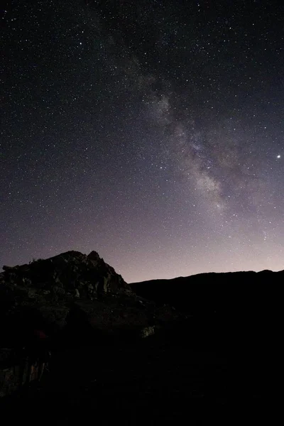 魔法の夜空の下で岩の風景の垂直ショット — ストック写真