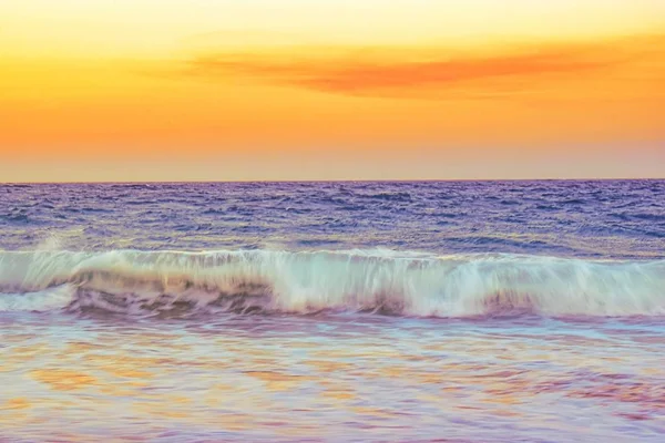 Пейзаж морських хвиль під час помаранчевого заходу сонця ввечері — стокове фото