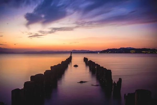 Paysage à couper le souffle de poteaux en bois au lac Shinji à Matsue, Japon pendant le coucher du soleil — Photo