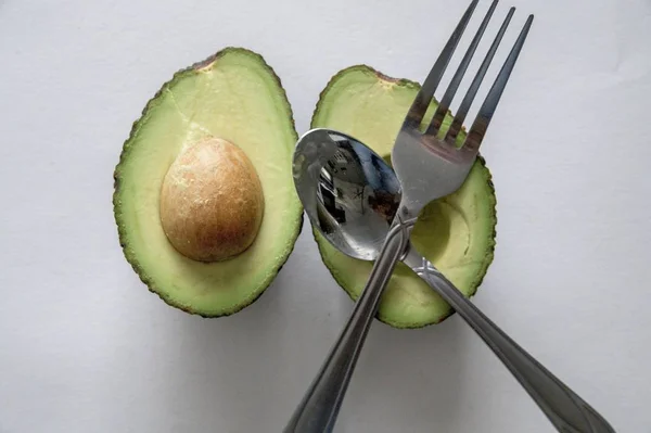 High angle shot of a fresh delicious avocado with silverware — Stock Photo, Image