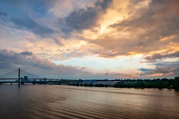 Słońce świecące za chmurami nad rzeką w mieście — Zdjęcie stockowe