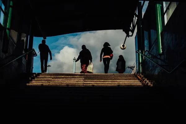 Groep mensen op de trap met de bewolkte lucht zichtbaar op de achtergrond — Stockfoto