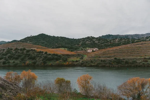 Una Casa Una Collina Vicino Lago Circondata Alte Montagne Rocciose — Foto Stock