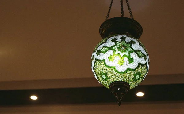 Low angle shot of a beautiful white and green pendant lamp in a room — Stock Photo, Image