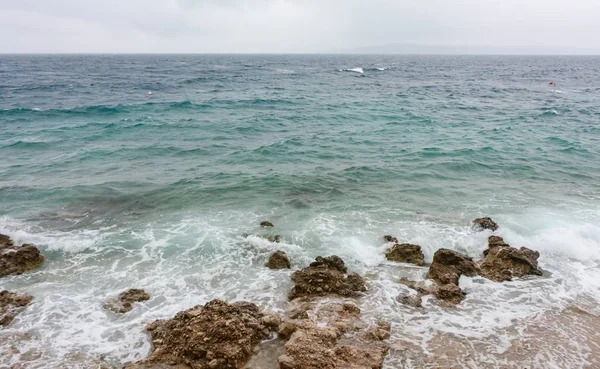 Mar Adriático con colinas cubiertas de niebla bajo un cielo nublado en el fondo de Croacia. — Foto de Stock