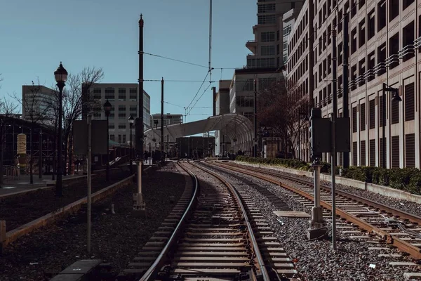 ノースカロライナ州シャーロットの太陽の下で建物に囲まれた鉄道道路 — ストック写真