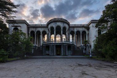Historical Derelict Sanatorium Medea in Tskaltubo, Georgia during the sunset clipart