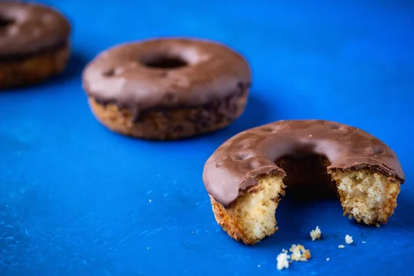 Primer Plano Donut Medio Comido Bañado Chocolate Sobre Una Superficie —  Fotos de Stock